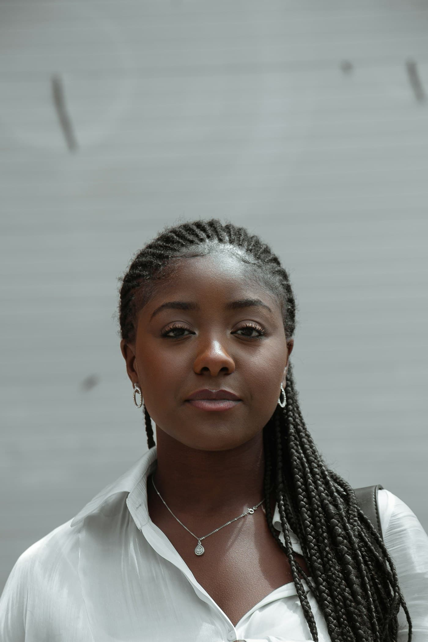 Woman with fine cornrows in a white shirt