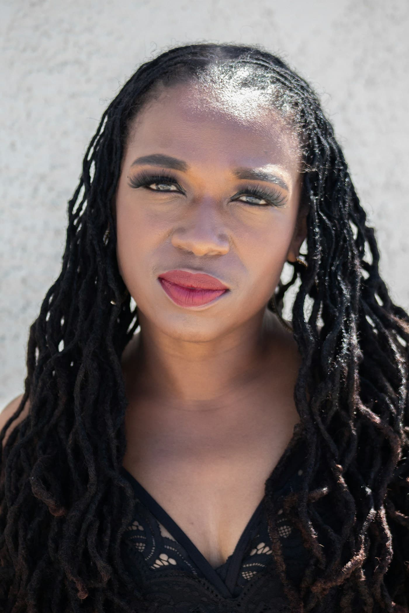 Woman with long locs and berry lipstick